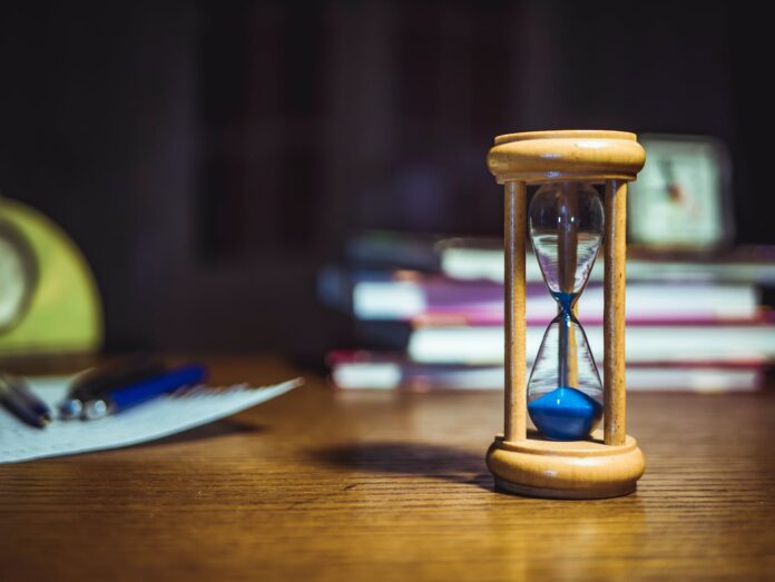 hourglass on brown wooden frame